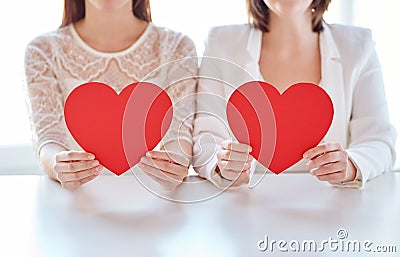 Close up of happy lesbian couple with red hearts Stock Photo