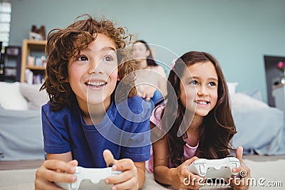 Close-up of happy siblings with controllers playing video game Stock Photo