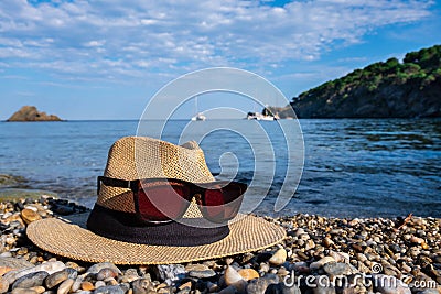 Close-up of a hat and sun glasses. Blue sea and sky. Stock Photo