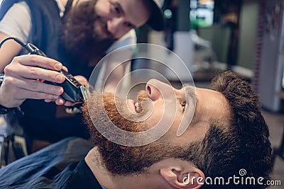 Close-up of the head of a man and the hand of a barber trimming Stock Photo