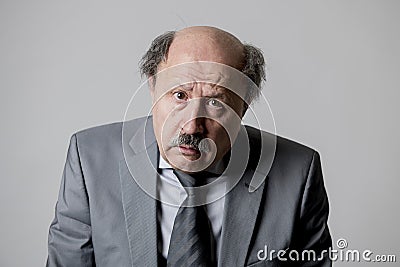 Close up head portrait of bald 60s senior business man sad and depressed looking funny and messy in sadness emotion Stock Photo