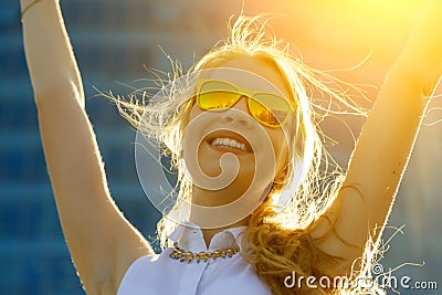 Close up head shot portrait of young woman with arms raised rejoicing summer Stock Photo