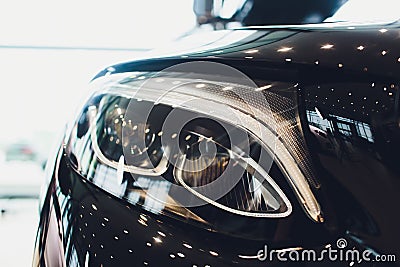 Close up headlights front side view , black color car in room. Stock Photo