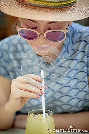 Close up headshot of beautiful woman drinking cool beverage in glass Stock Photo