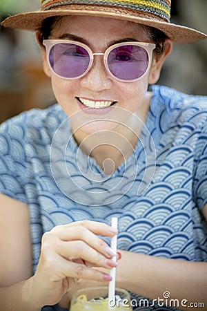 Close up headshot of beautiful woman drinking cool beverage in glass Stock Photo