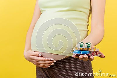 Close up of heap of blisters of pills in pregnant woman`s hand at colorful background with copy space. Healthcare and treatment Stock Photo
