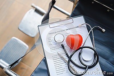 Close up heart ball and stethoscope on empty wheelchair Stock Photo