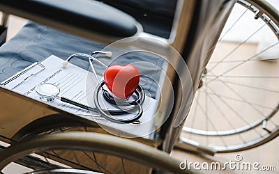Close up heart ball and stethoscope on empty wheelchair Stock Photo