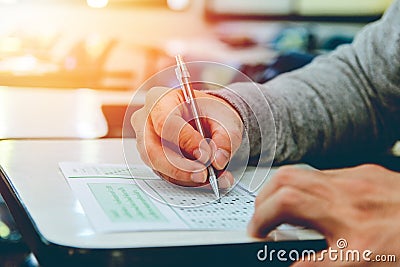 Close up , High School male student holding pencil exams writing in classroom for education test ,Copy space for your text. Stock Photo