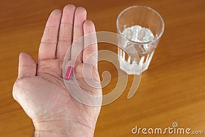 Close up holding pill and glass of water Stock Photo