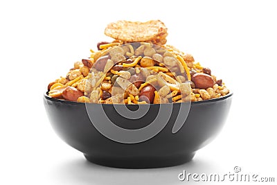 Close-Up of Hot spicy Nav Ratan snacks in a black Ceramic bowl, made with red chili, peanuts. Indian spicy snacks Namkeen Stock Photo