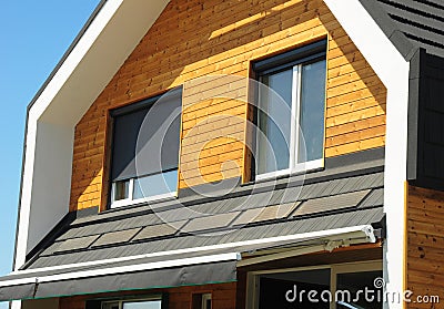 Close up on House Blinds Sun Protection Exterior. Windows in New Modern Passive House Facade Wooden Wall with Shutters Closed and Stock Photo