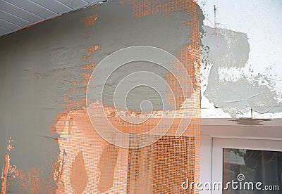 Close up on house plastering wall withfiberglass mesh, plaster mesh after rigid insulation. Stock Photo