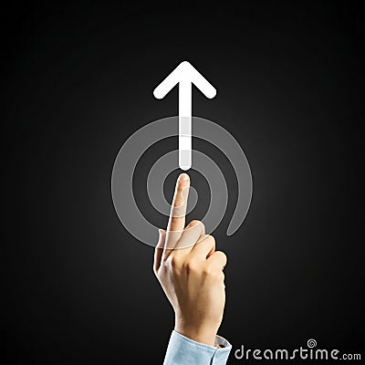 Close up of human hand pointing with finger at white arrow on black background Stock Photo