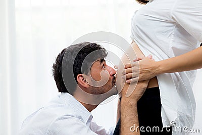 Close up husband kiss pregnant woman belly Stock Photo