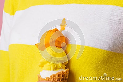 Close up an ice cream cone with three scoops of different flavor spilled a stain on clothes. Stock Photo