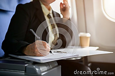 Close-up image of a businesswoman reviewing business reports while boarding a plane Stock Photo