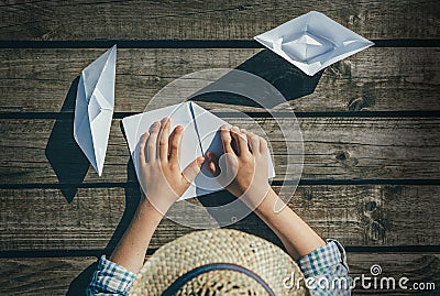 Close up image child hands with paper boats on wooden pier Stock Photo