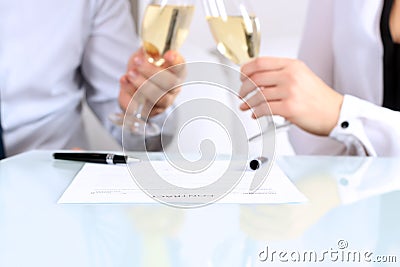 Close-up image of a contract . two colleagues celebrate signing a contract with champagne Stock Photo