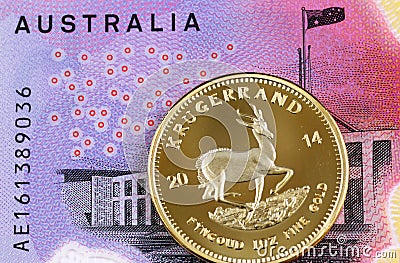 A five Australian dollar bill with a South African golden Krugerrand coin Stock Photo