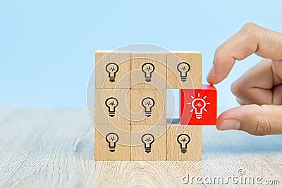 Close-up image of hand-picked cube shaped wooden toy blocks with light bulb symbol stacked ideas for creativity Stock Photo