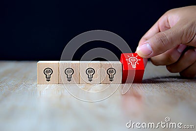 Close-up image of hand-picked cube shaped wooden toy blocks with light bulb symbol stacked ideas for creativity Stock Photo