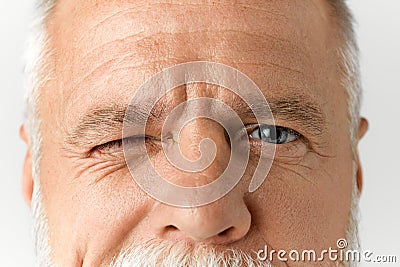 Close-up image of male face with blue eyes looking at camera. Vision care. Mature model with wrinkles on forehead Stock Photo