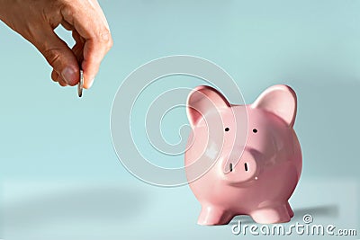 Close up image male fingers puts coin by not in the piggy bank. Not Save money, think about future, avoid unnecessary expenses, Stock Photo