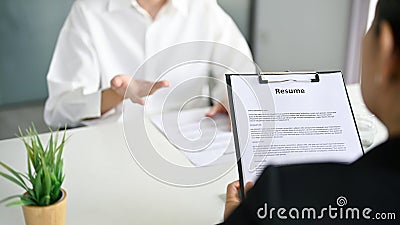 Close-up image of a recruiter reading a candidate's resume during a job interview Stock Photo