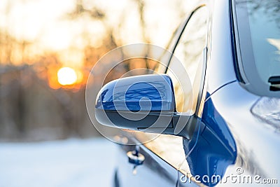 Close up Image of Side Rear-view Mirror on a Car in the Winter Landscape with Evening Sun Stock Photo