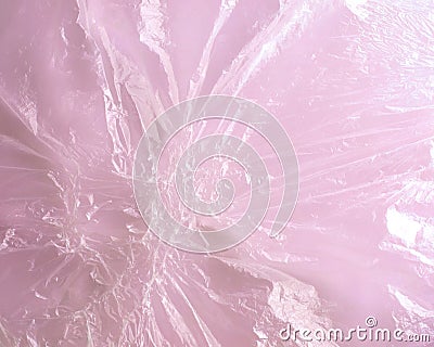 Close-up image of transparent melted plastic cellophane film on pink background. Stock Photo