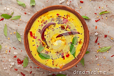 Close-up of Indian traditional kadhi or kadi pakora yogurt and gram flour and turmeric served hot in a clay bowl. garnished with f Stock Photo