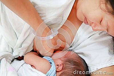 Close-up infant baby feeding from mother breastfeeding her newborn child on the hospital bed Stock Photo