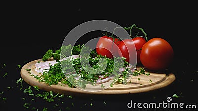 Close-up of ingredients on wooden cooking board on black isolated background. Frame. Handful of green fragrant parsley Stock Photo