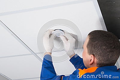 Close-up of the installation of a motion sensor for lighting automation, with hands in protective gloves of an electrician Stock Photo