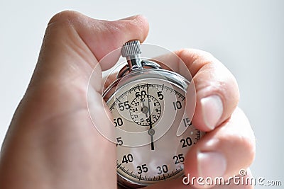 A close-up of an isolated hand presses the stopwatch start button in the sport, measurements, metrology Stock Photo