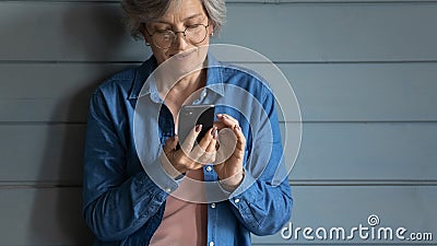 Close up isolated mature woman wearing glasses using smartphone Stock Photo