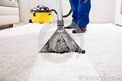 Janitor Cleaning Carpet With Vacuum Cleaner Stock Photo