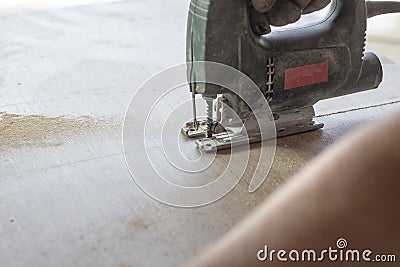 close-up. jigsaw. hands of the employee. they are sawing plywood Stock Photo