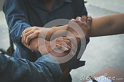 Close up of joining hands of three businessmen in unity cross processing background Stock Photo