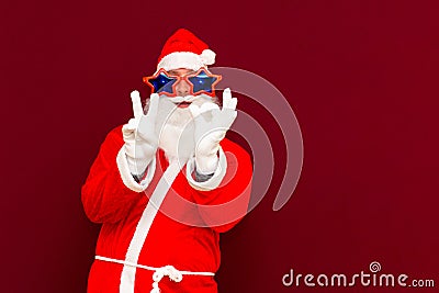 Close up joyful funny playful santa showing peace victory and zero signs, fooling around, in trendy specs, so confident Stock Photo