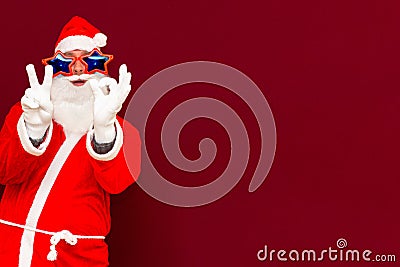 Close up joyful funny playful santa showing peace victory and zero signs, fooling around, in trendy specs, so confident Stock Photo