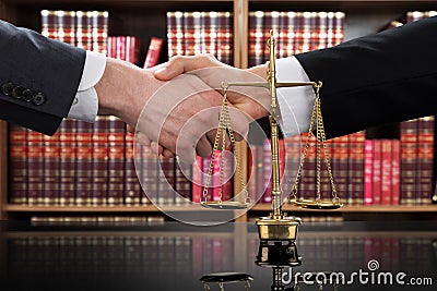 Justice Scale With Judge And Client Shaking Hands Stock Photo