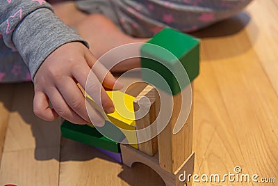 Close up of a Kid hand Playing with Colourful Blocks Stock Photo