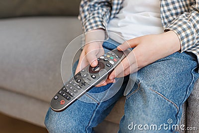 Close-up kid hands holding TV remote controller. Boy without parental control watching television Stock Photo