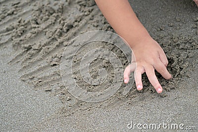 Close up kid`s hand and fingers, play and learn at the beach Stock Photo