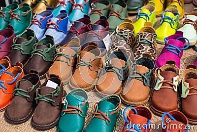 Close up of kids colorful handmade leather shoes at the fair. Stock Photo