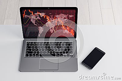 Close up of laptop and cellphone on desktop with falling red forex hologram on white background. Stock crisis price drop down Editorial Stock Photo