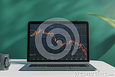 Close up of laptop computer with falling red crisis forex chart on screen. Desktop and chalkboard background. Recession, trade and Stock Photo