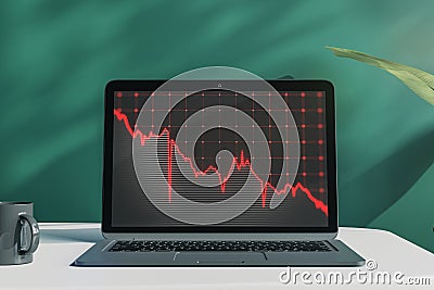 Close up of laptop on desktop with coffee cup, falling red business graph grid on chalkboard background. Crisis, recession and Stock Photo